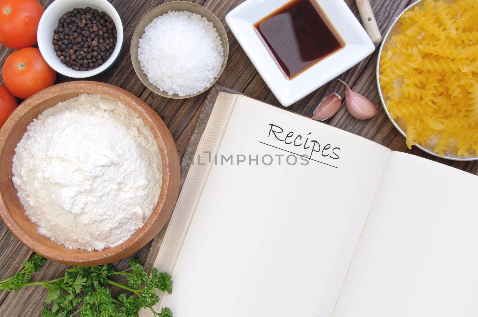 Open recipe book surrounded by cooking ingredients