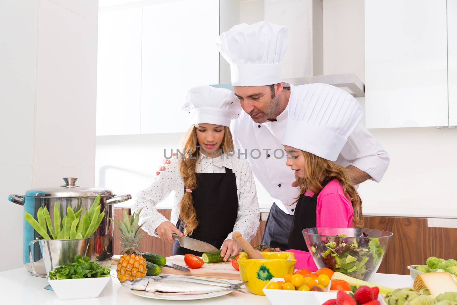 Chef master and junior pupil kid girls at cooking school with food on countertop