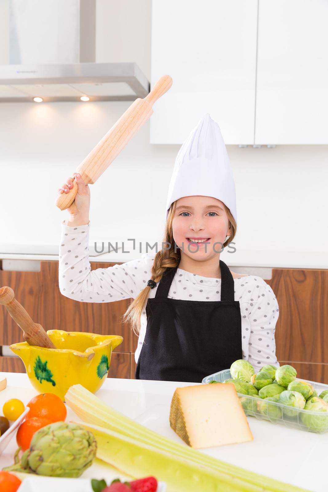 kid girl chef on countertop funny gesture with roller knead by lunamarina