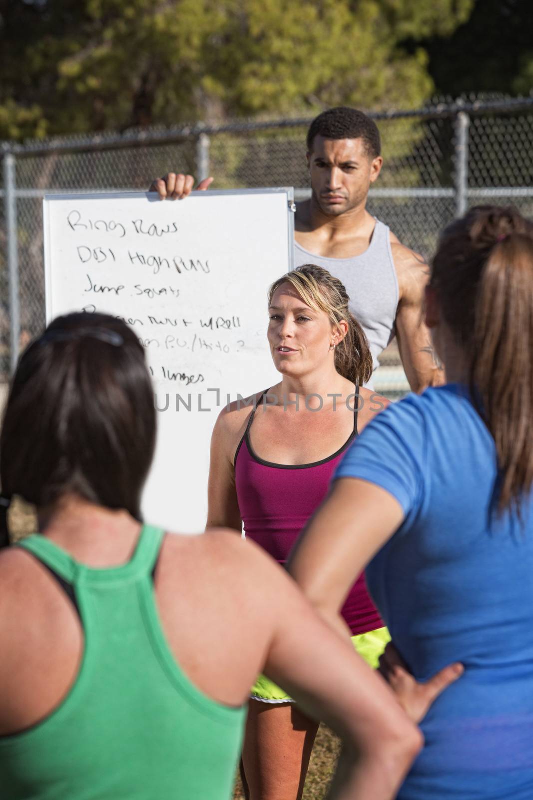 Fitness trainers explaining an exercise program outdoors