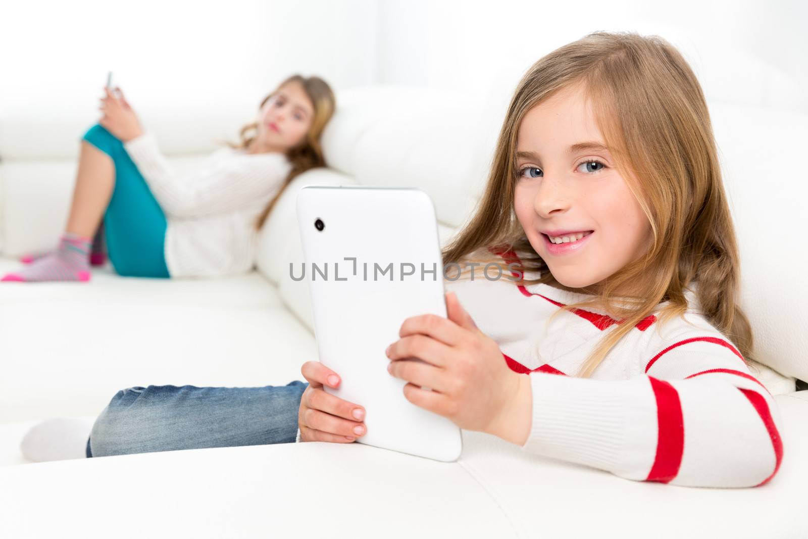 sister friends kid girls playing with tablet pc in sofa by lunamarina