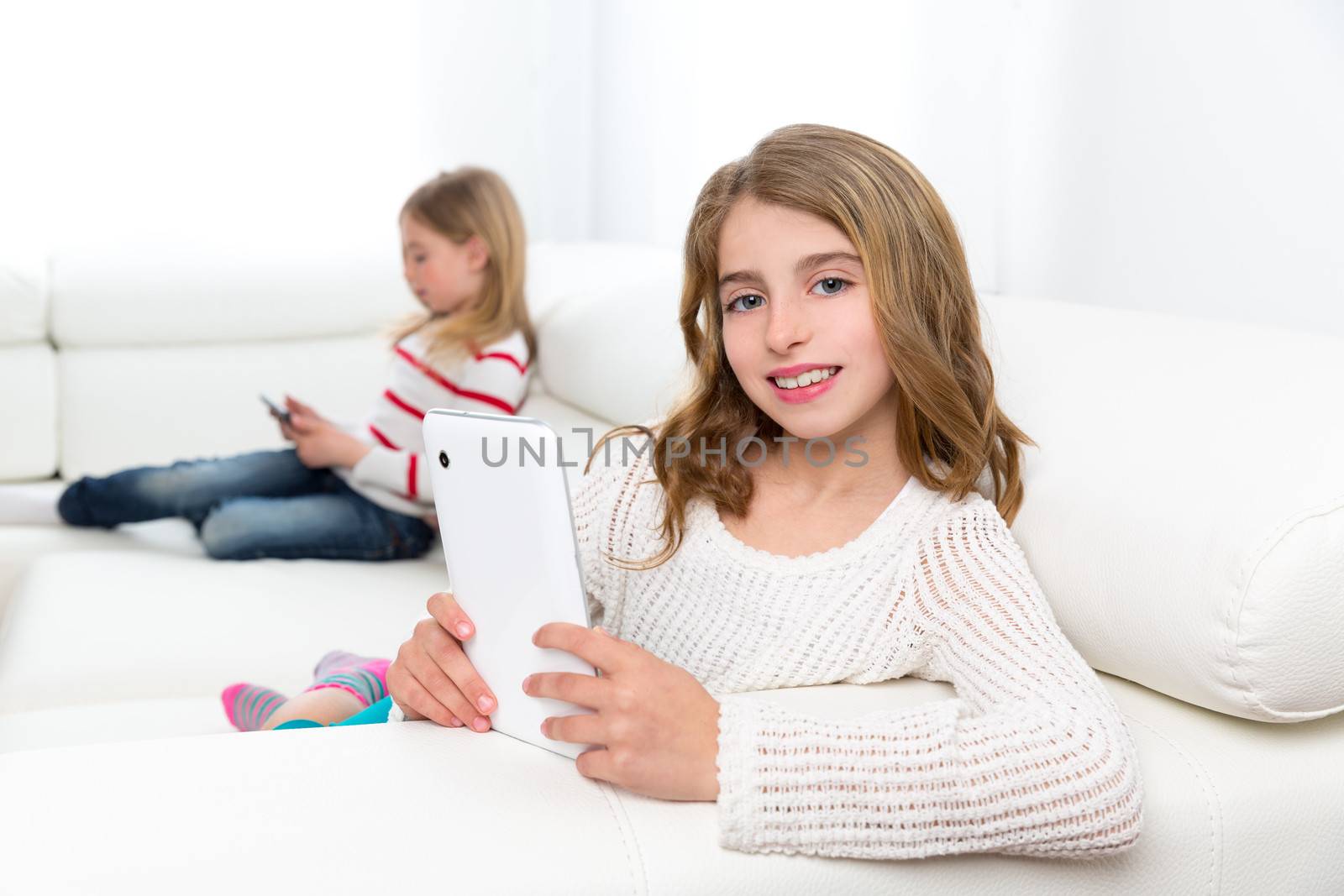 sister friends kid girls playing with tablet pc in sofa by lunamarina