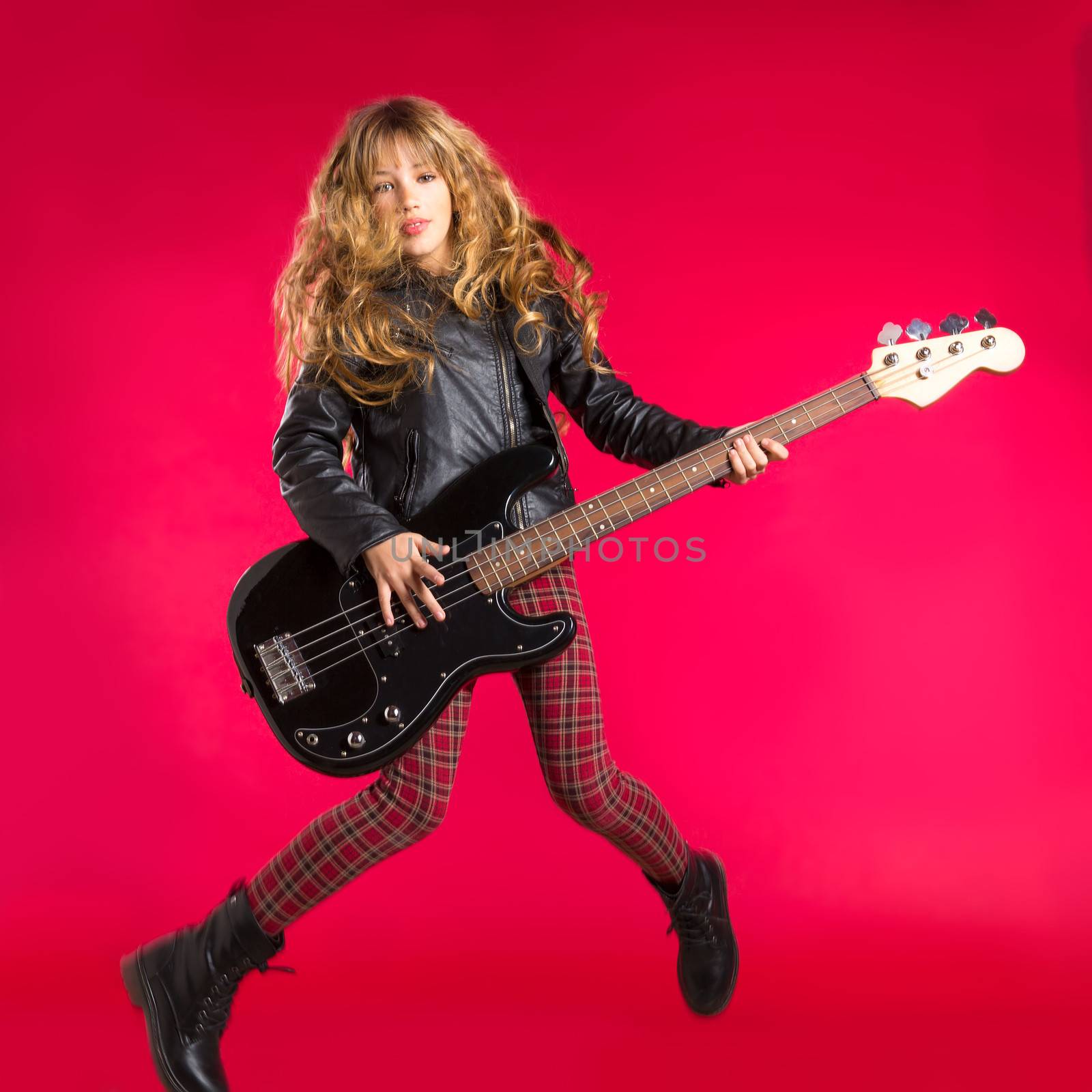 Blond Rock and roll girl with bass guitar jump on red by lunamarina