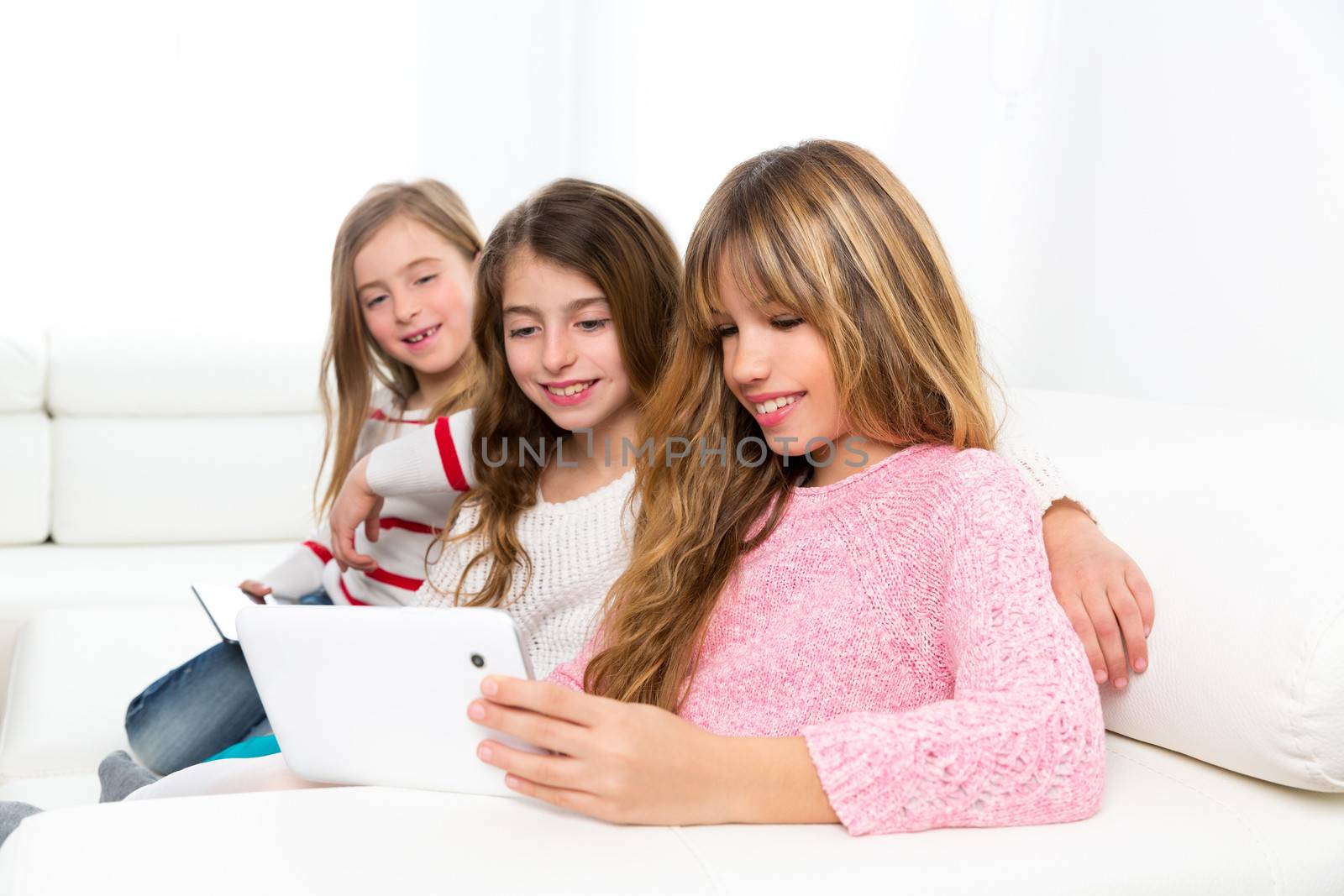 three kid sister friends girls playing together with tablet pc by lunamarina