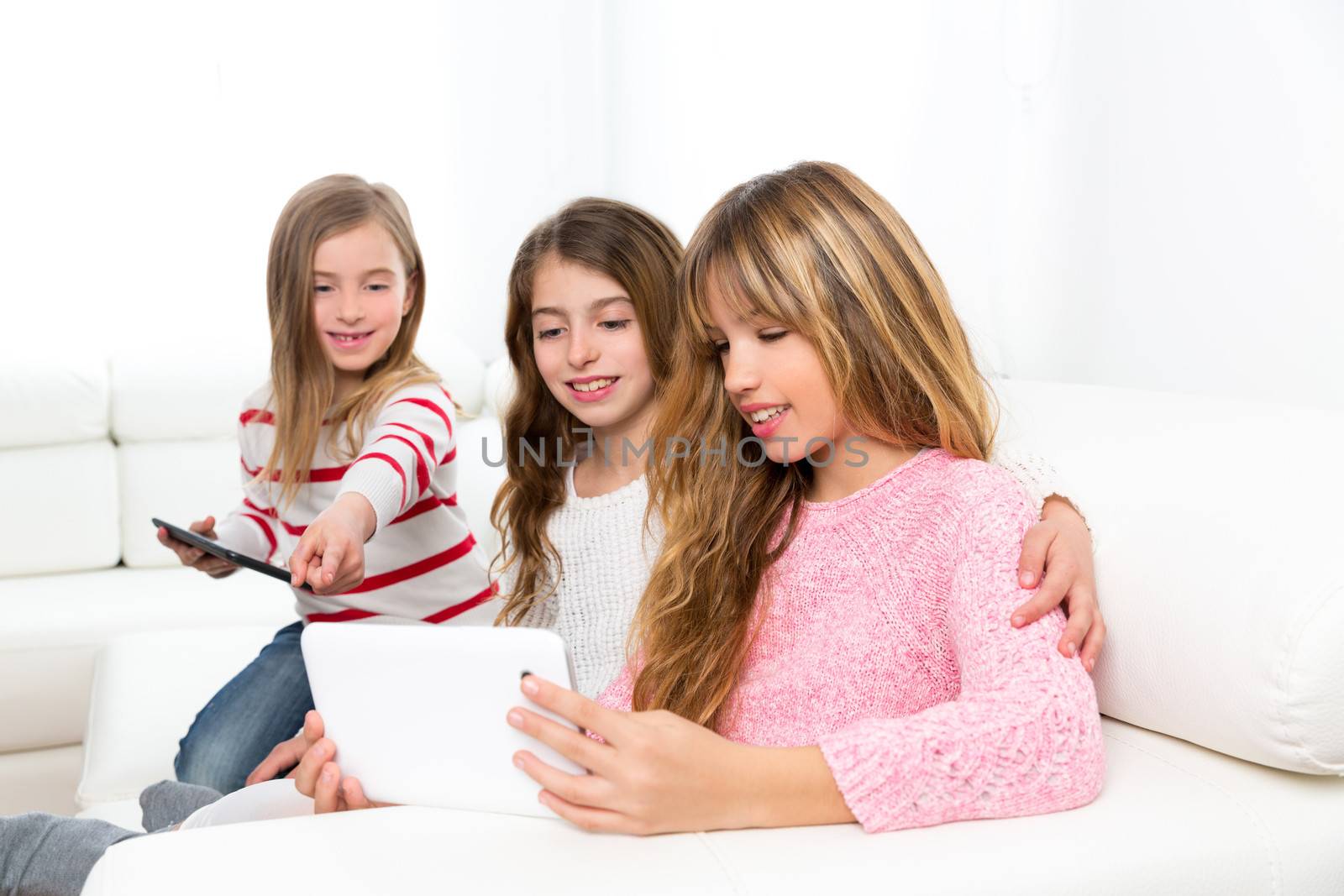 three kid sister friends girls playing together with tablet pc by lunamarina