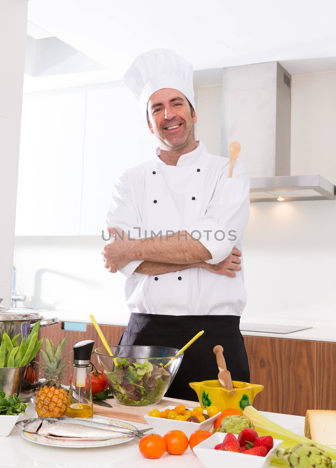 Chef male portrait on white countertop with food at kitchen