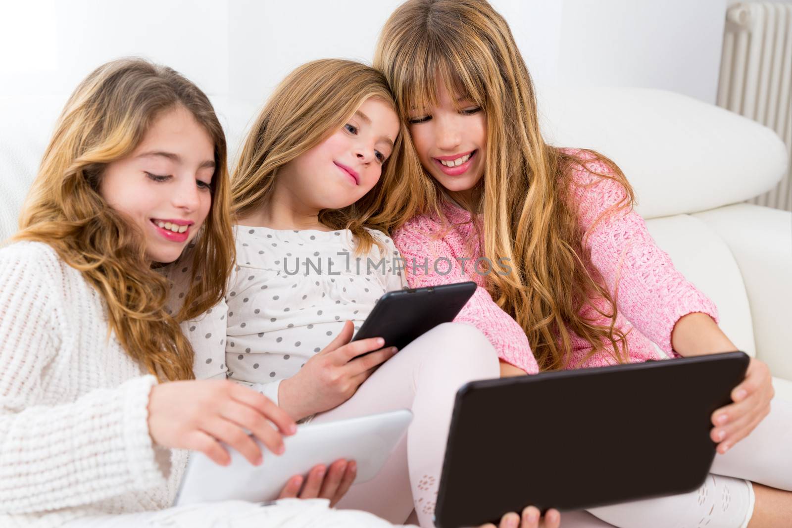 three kid sister friends girls group playing together with table by lunamarina