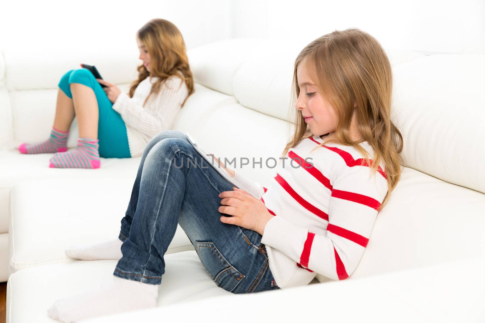 sister friends kid girls playing with tablet pc in sofa by lunamarina