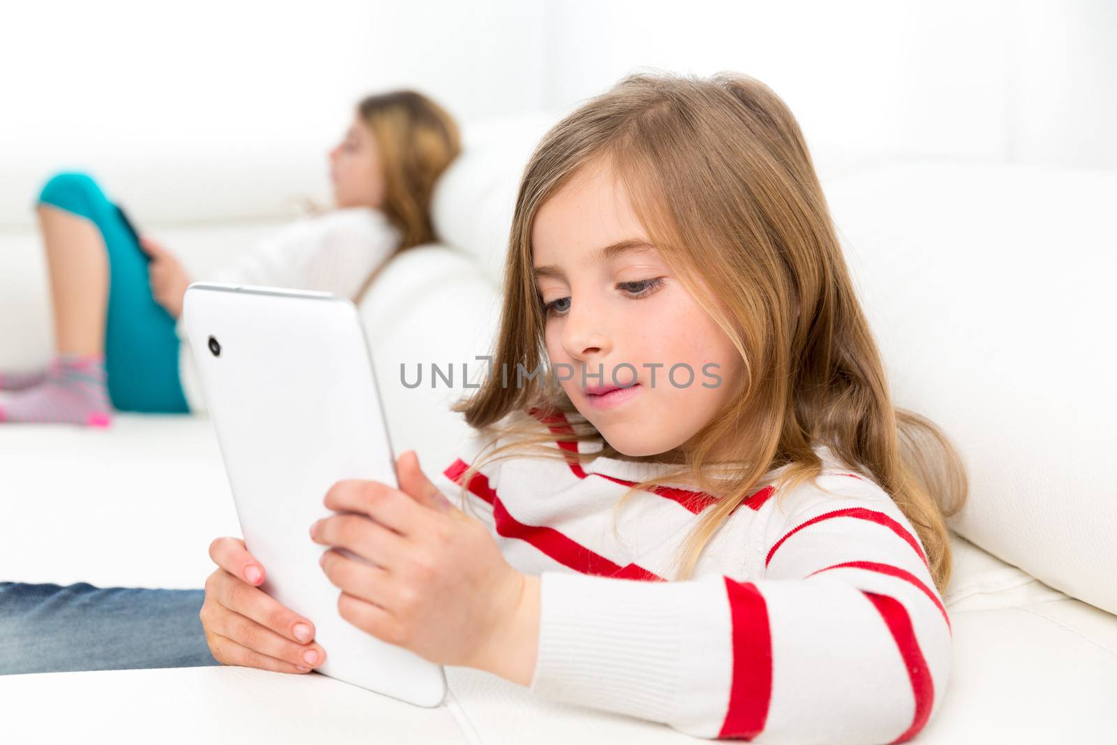 sister friends kid girls playing with tablet pc in sofa by lunamarina