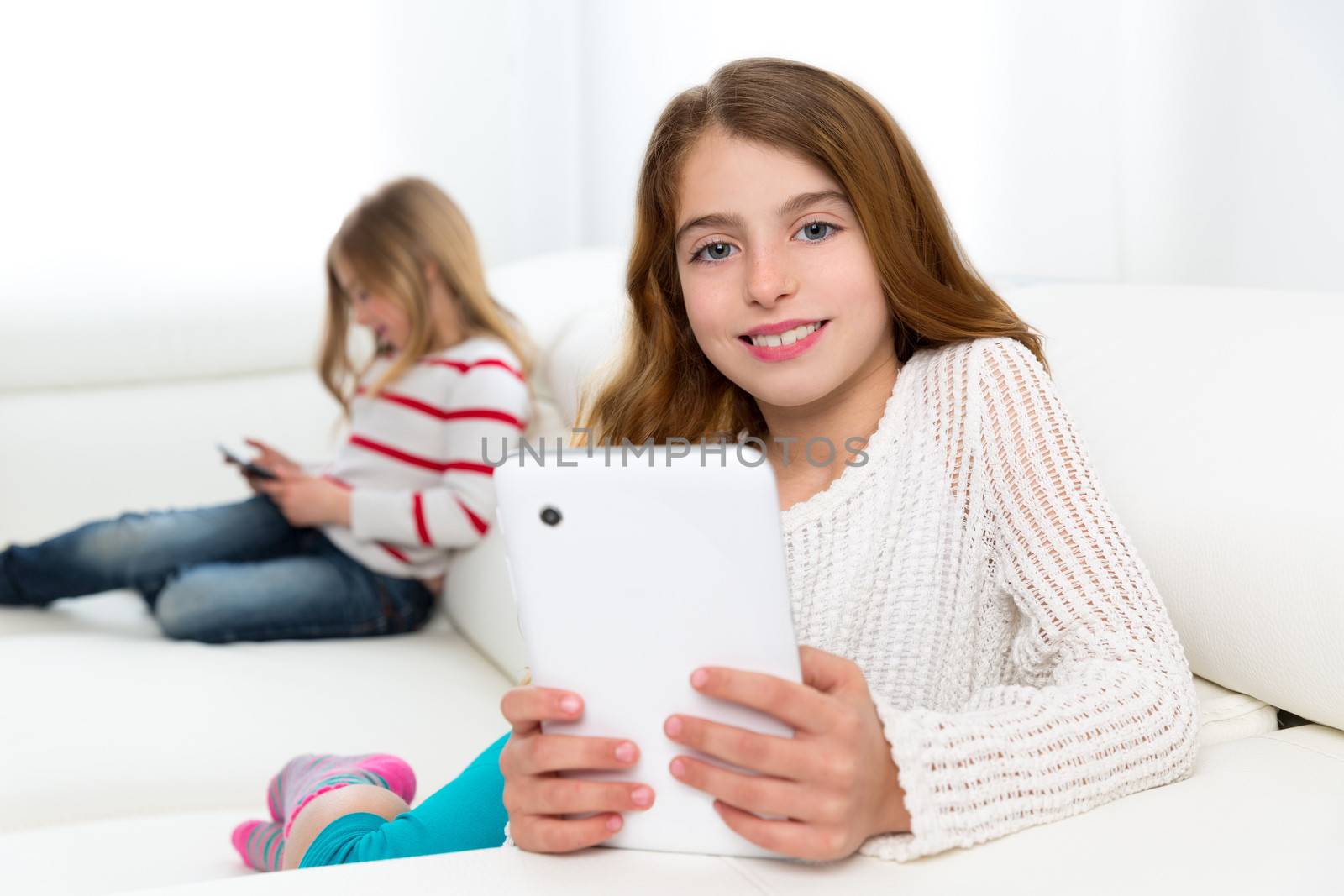 sister friends kid girls playing with tablet pc in sofa by lunamarina