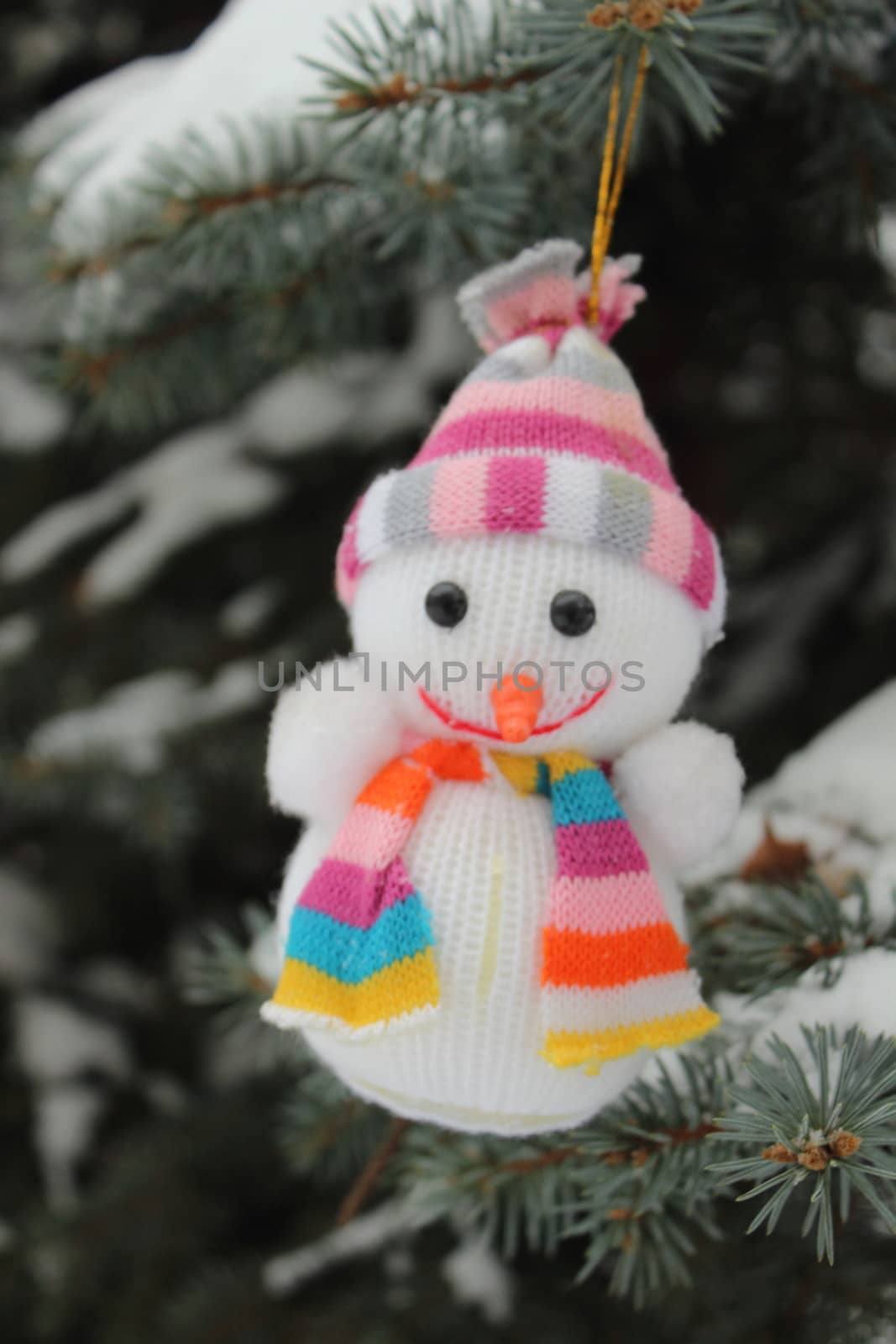 Funny merry christmas snowman hanging on a snowy tree