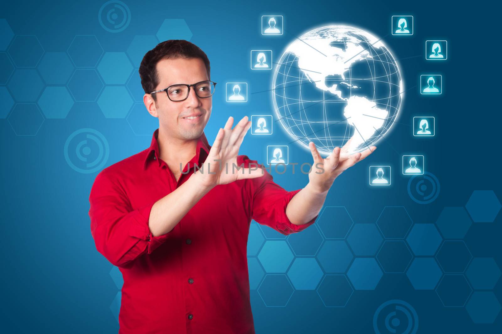 Business man in red shirt using futuristic global network marketing interface of hologram Earth with male female icons on blue.