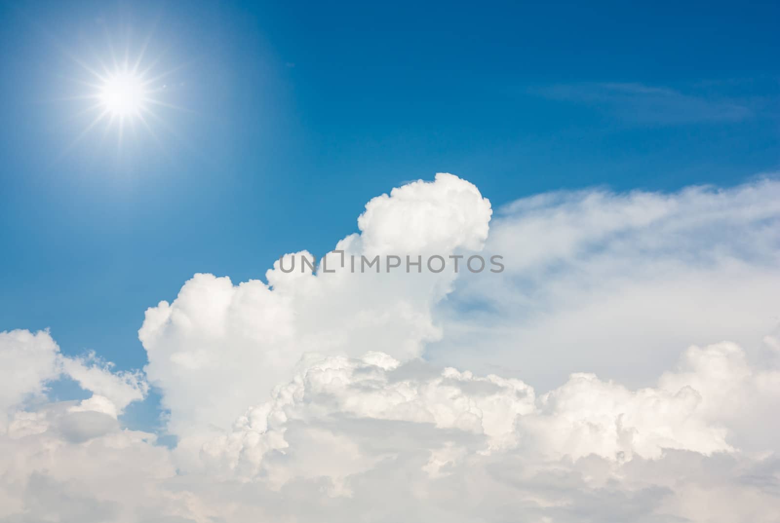 The sun and white clouds background in blue sky