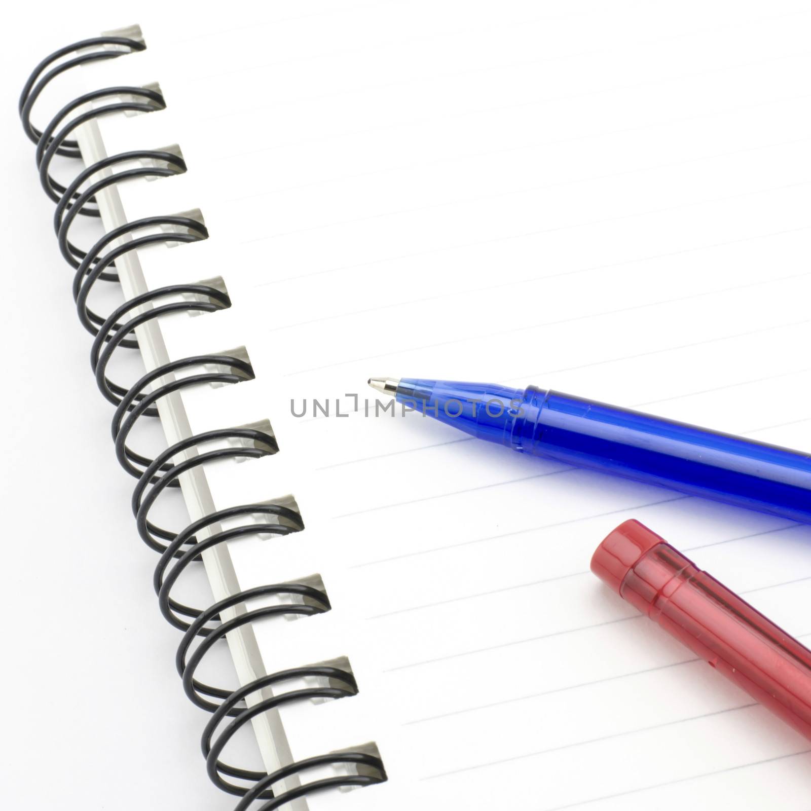 blue and red pen with notebook isolated on white by ammza12