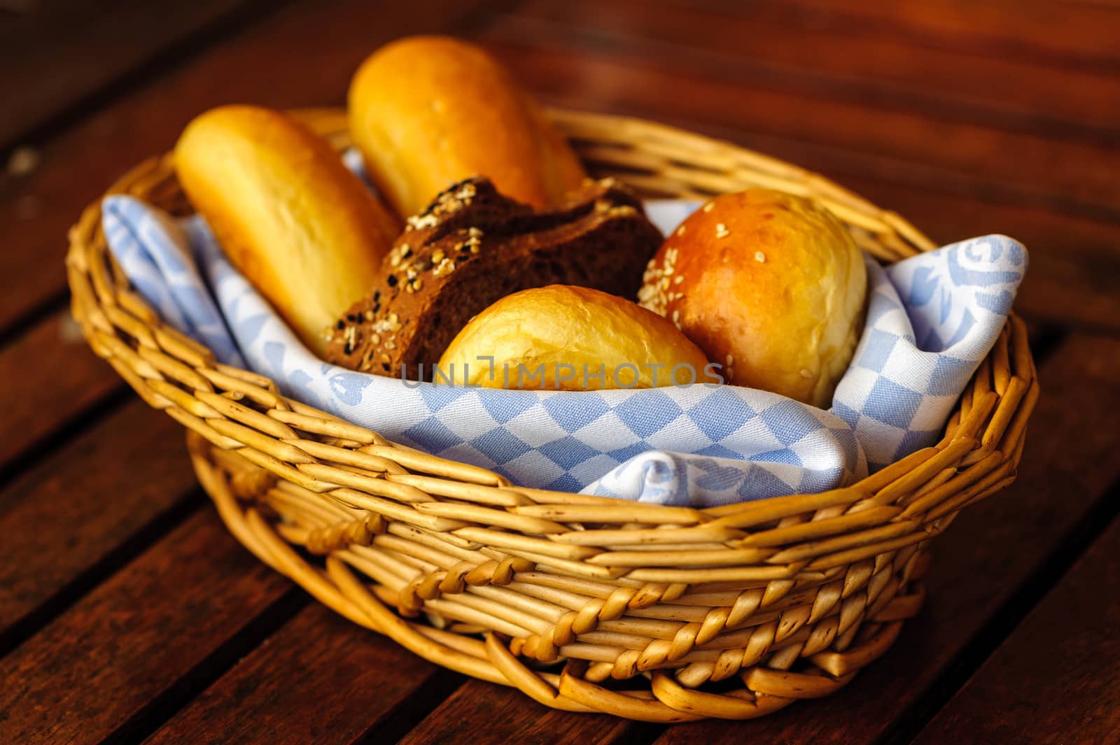 Various breads in basket on a table.
