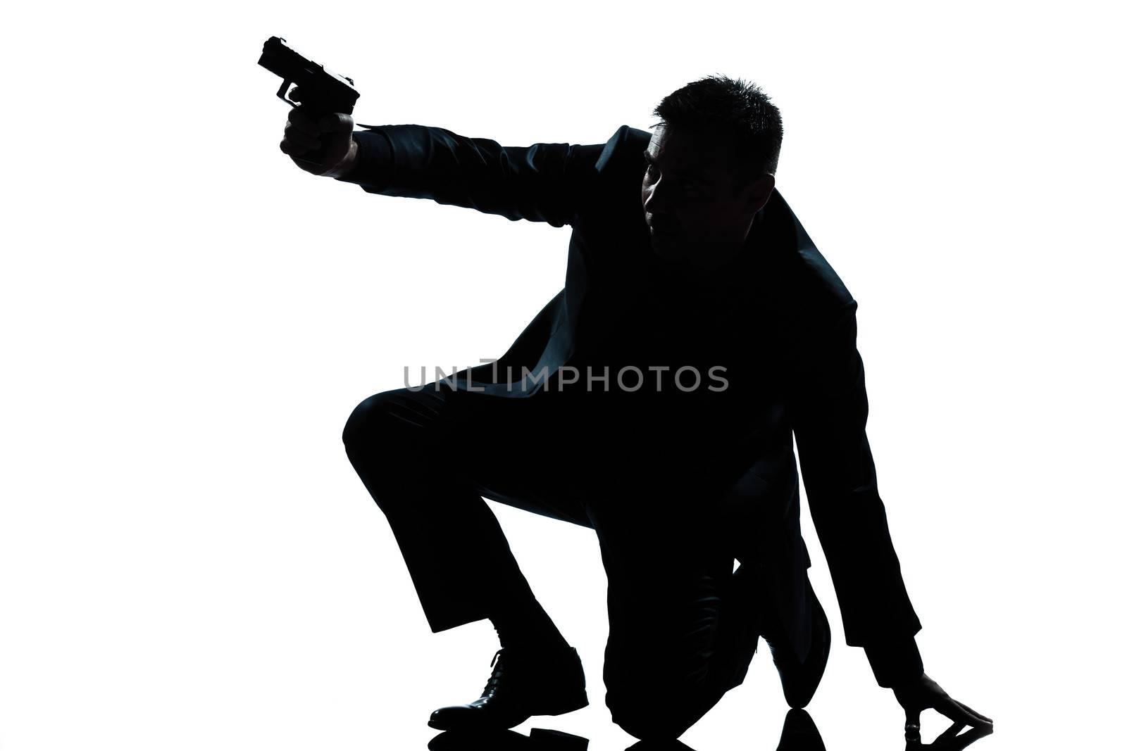 one caucasian spy criminal policeman detective man aiming shooting gun full length silhouette in studio isolated white background