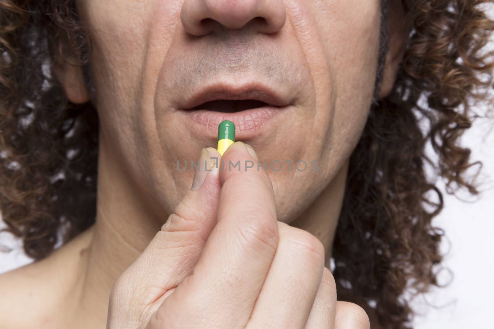 Cropped portrait of mediterranean looking man taking medicine pill