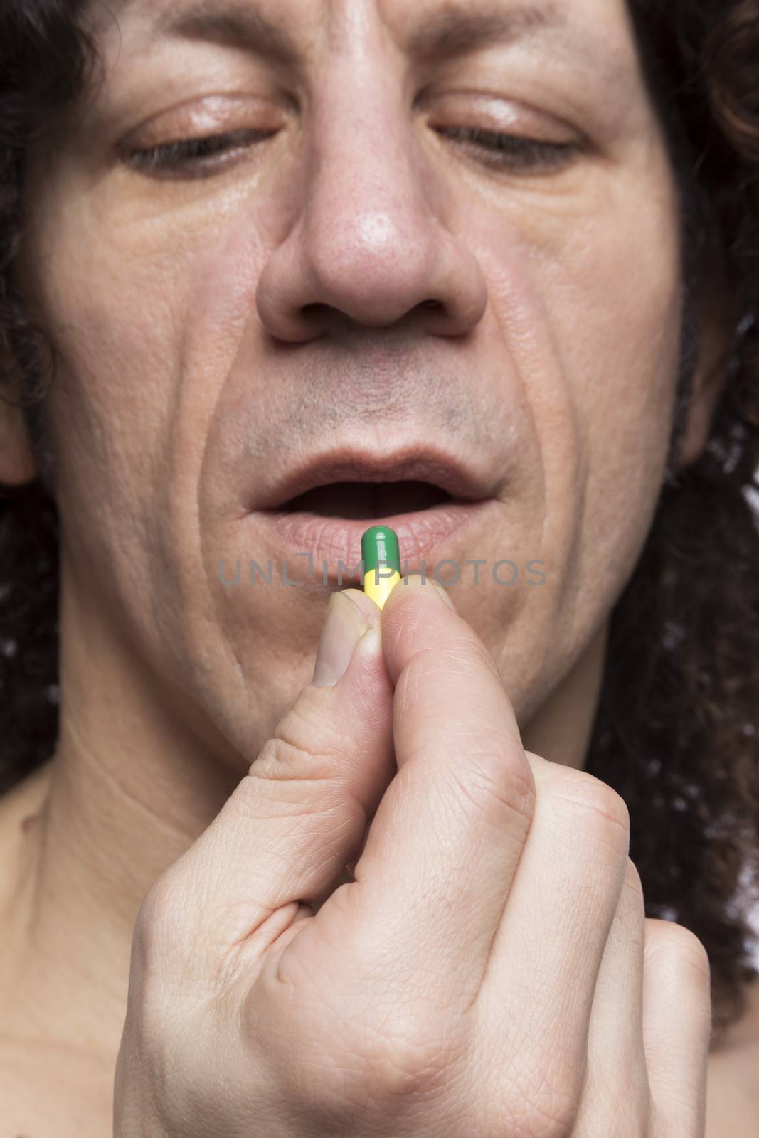 Cropped portrait of mediterranean looking man taking medicine pill