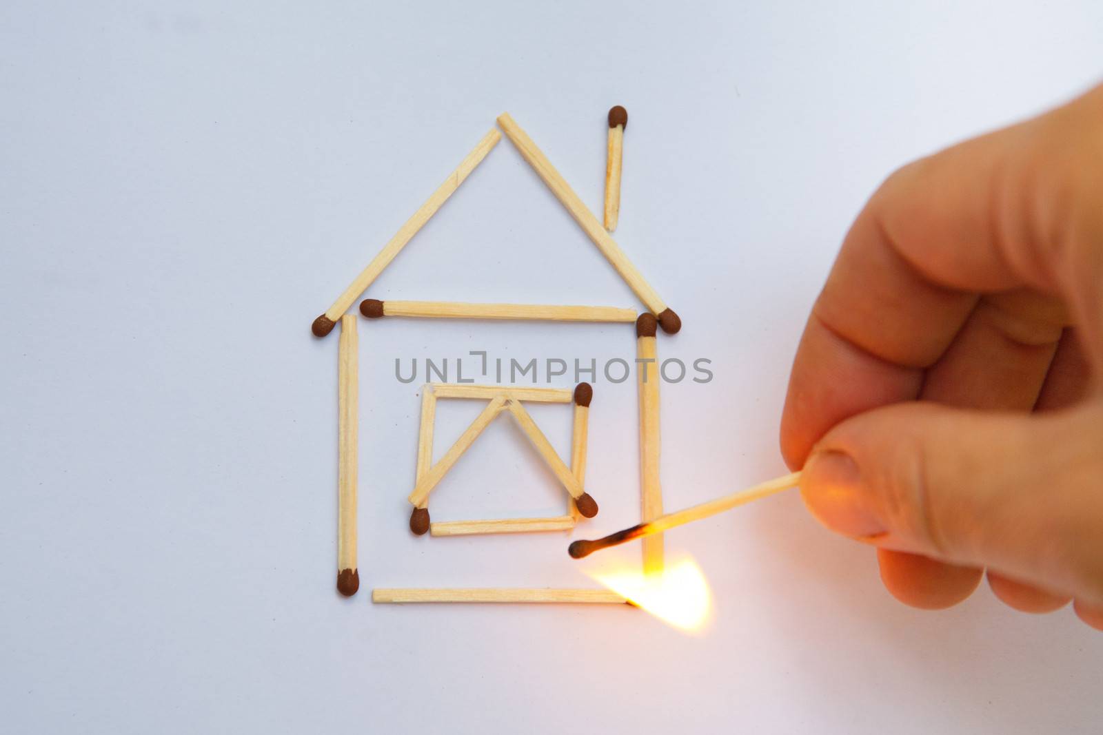 burning match near model of the house