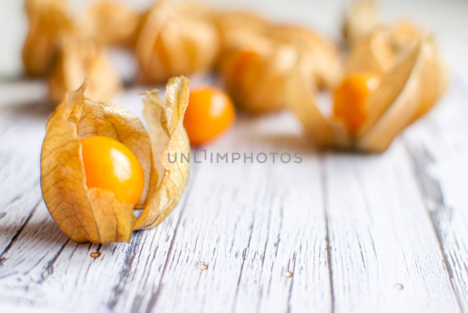 ripe healthy orange physalis over wooden board