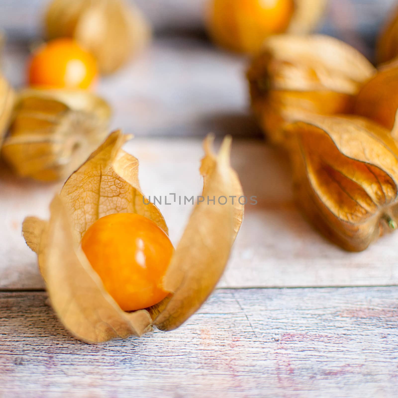 ripe healthy orange physalis over wooden board