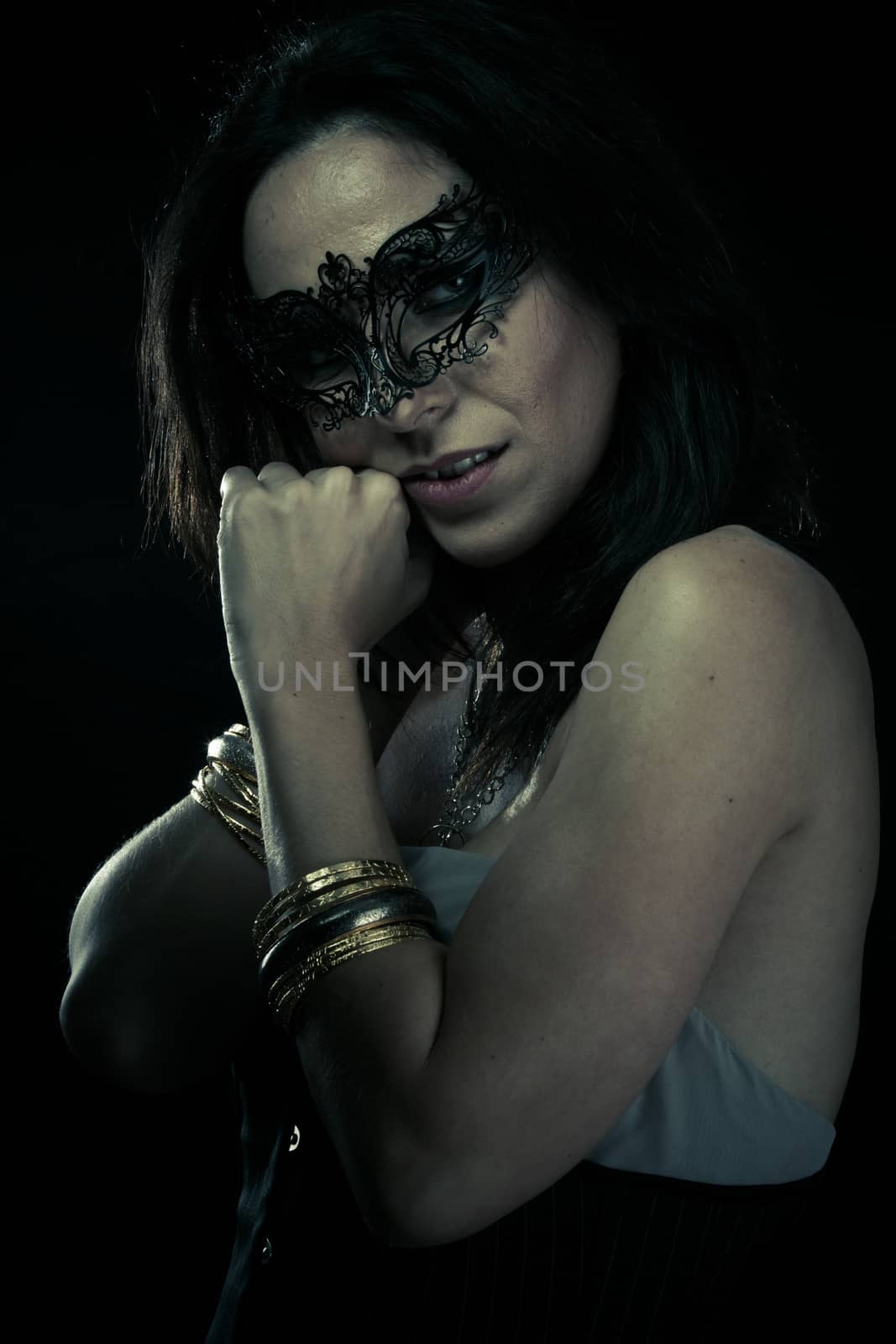 Mysterious.Beautiful young woman in mysterious black Venetian mask. Fashion photo. tribal design.