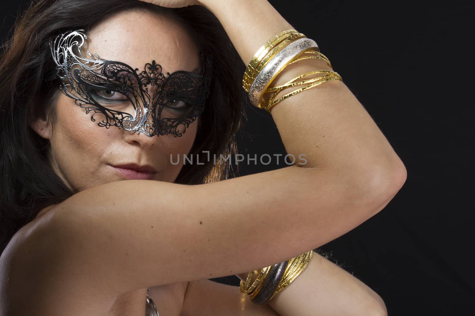 Beautiful young woman in mysterious black Venetian mask. Fashion by FernandoCortes