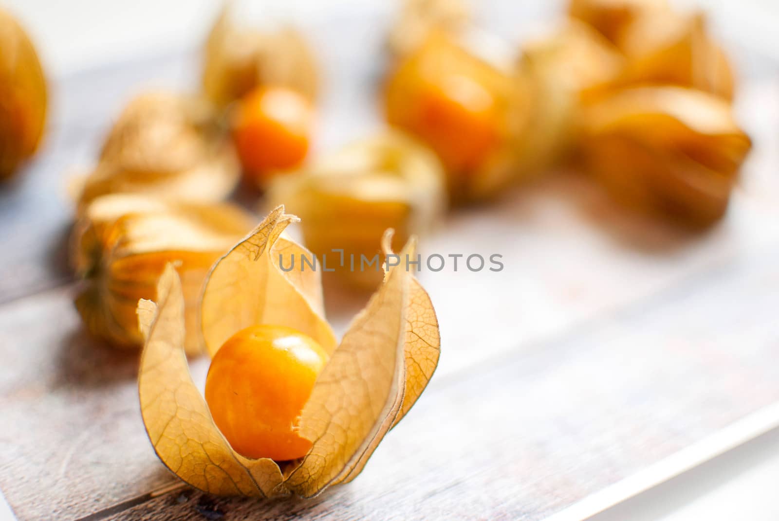 ripe healthy orange physalis over wooden board