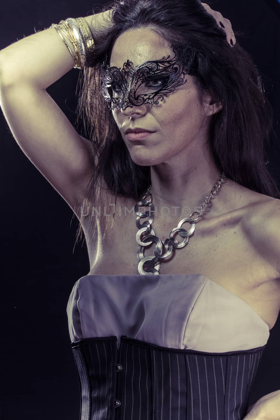 Beautiful young woman in mysterious black Venetian mask. Fashion photo. tribal design.