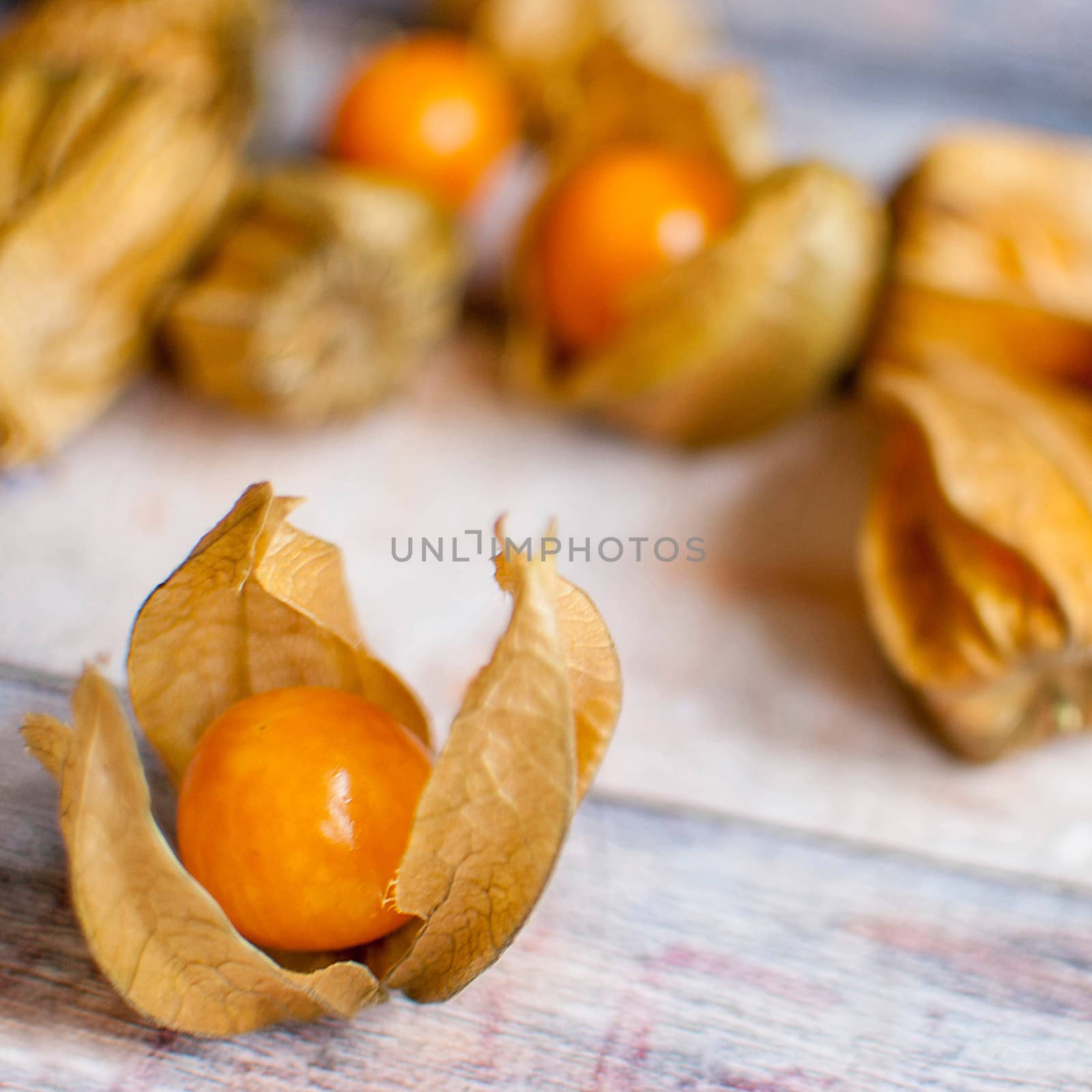 ripe healthy orange physalis over wooden board