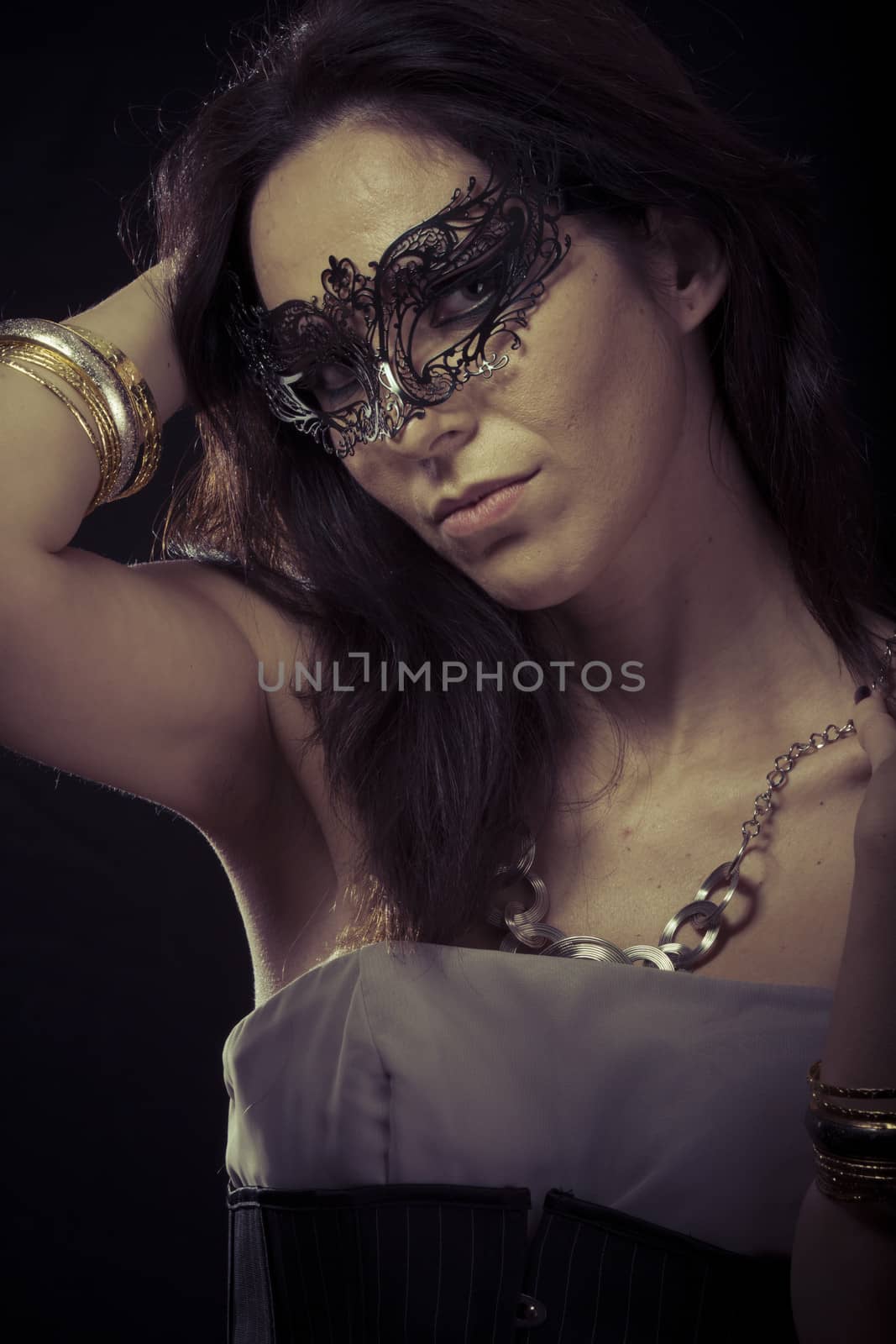 Beautiful young woman in mysterious black Venetian mask. Fashion photo. tribal design.