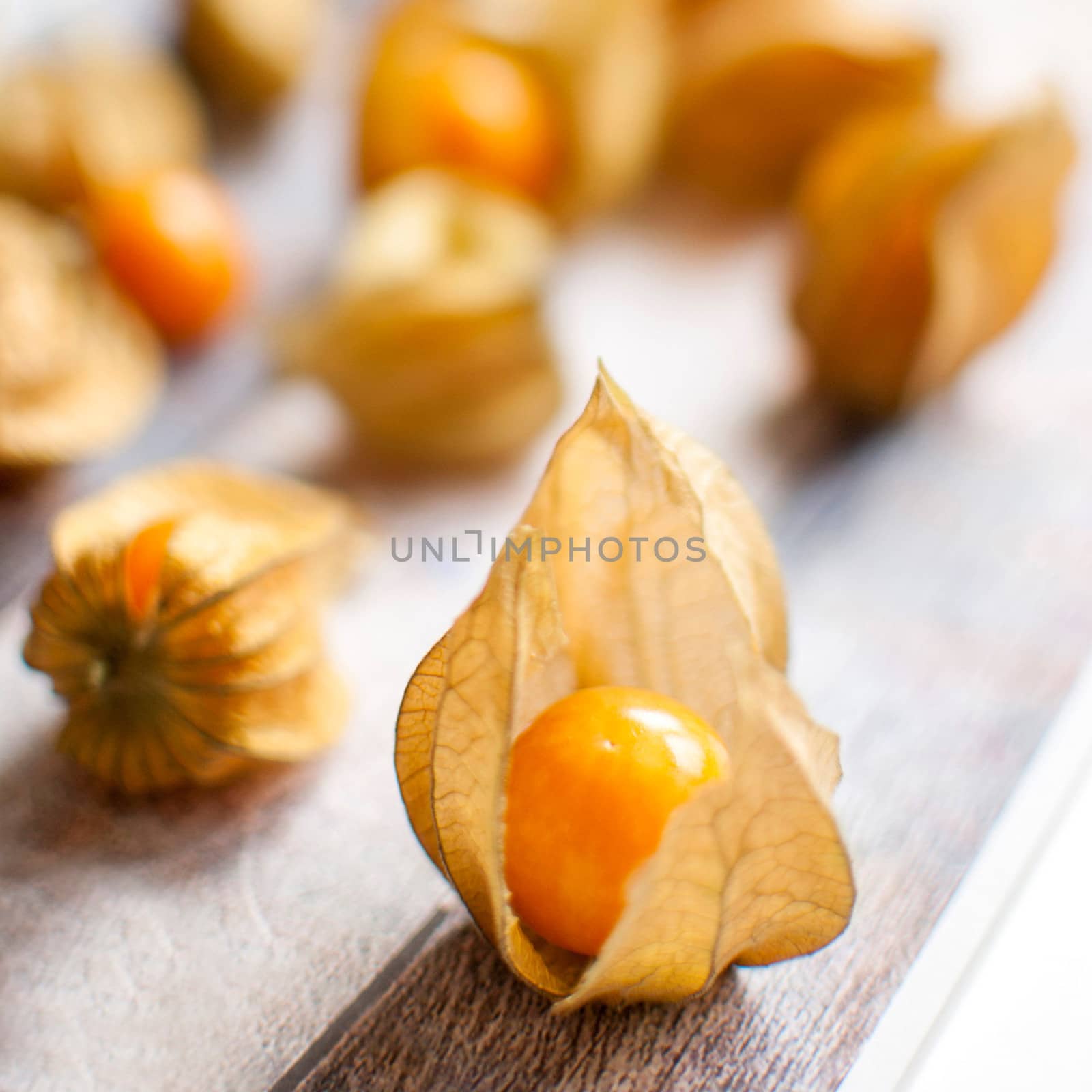 ripe healthy orange physalis over wooden board