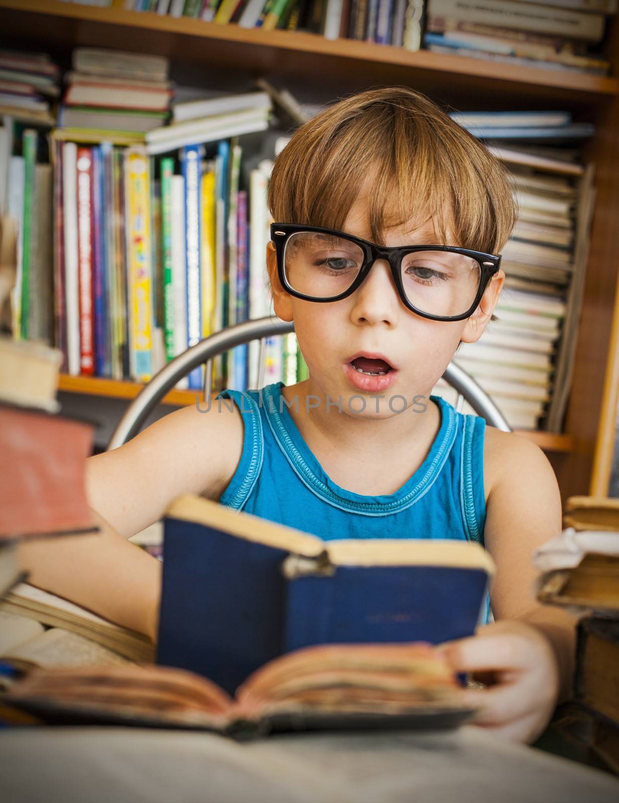 Close-up of cute boy reading book while preparing for lesson in library