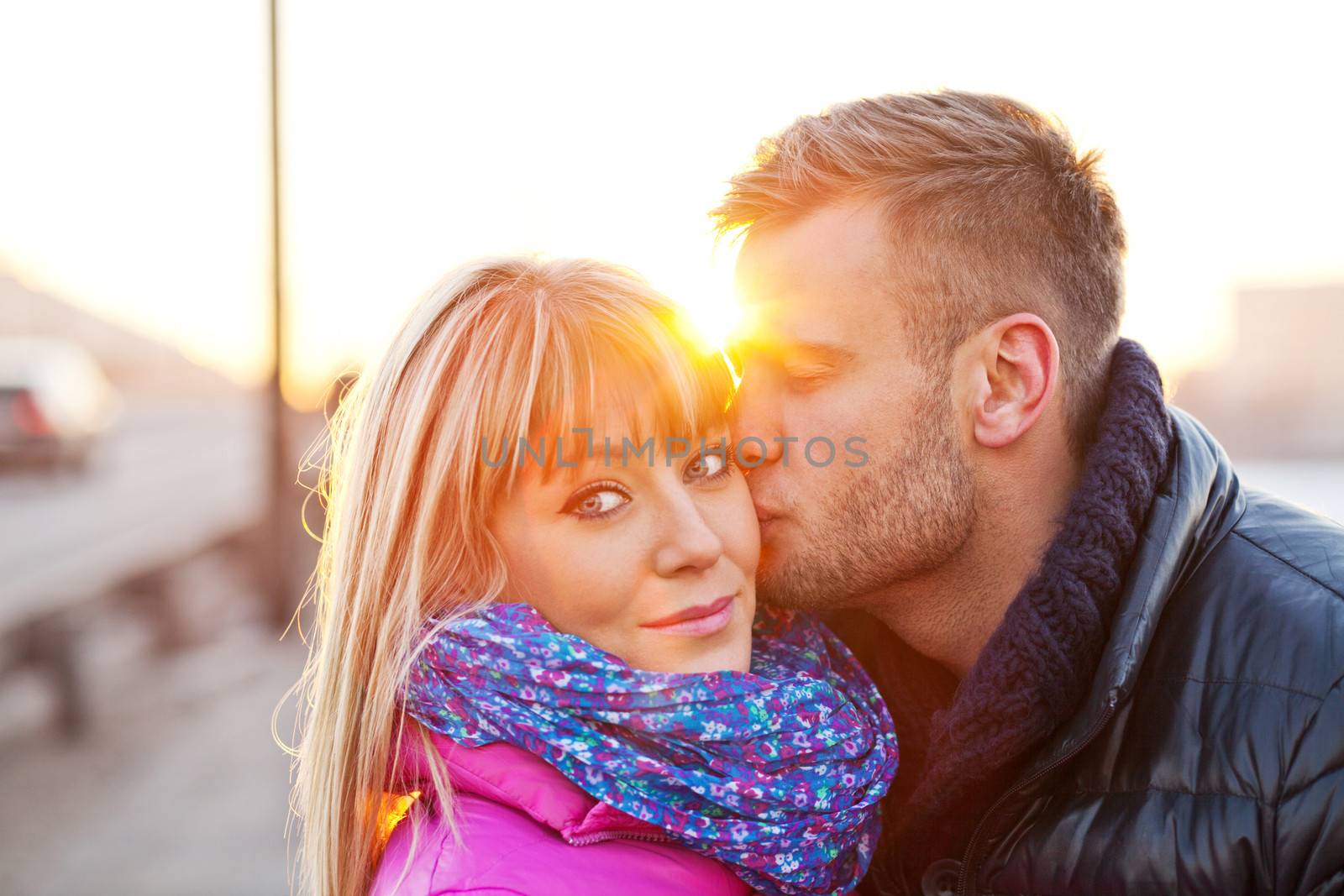 Young man kissing his girlfriend on the cheek