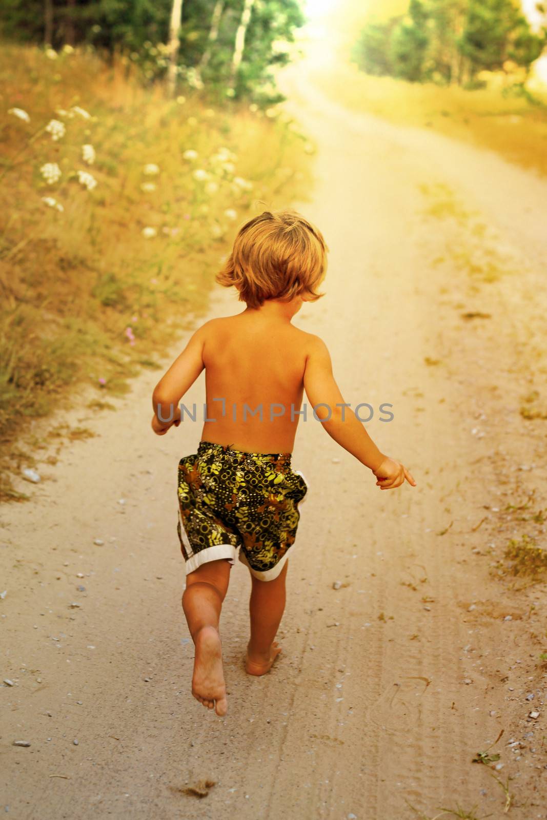 Boy running along road in park, outdoor