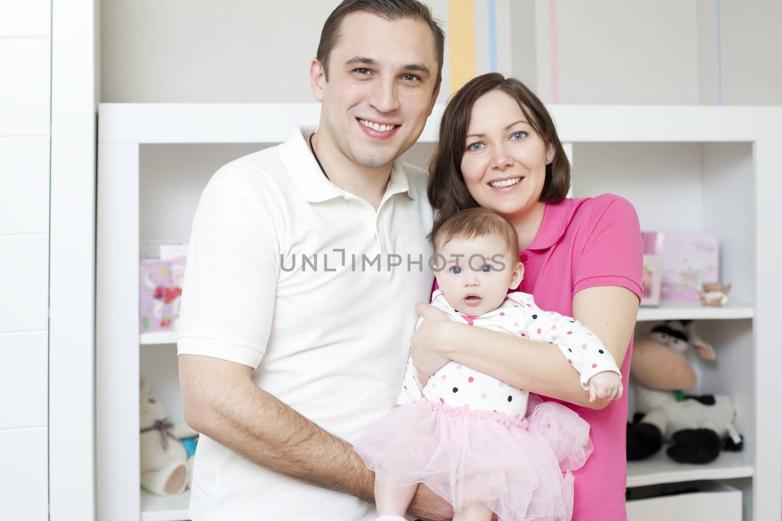 Happy family at home mother and father holding their young ballet dancer