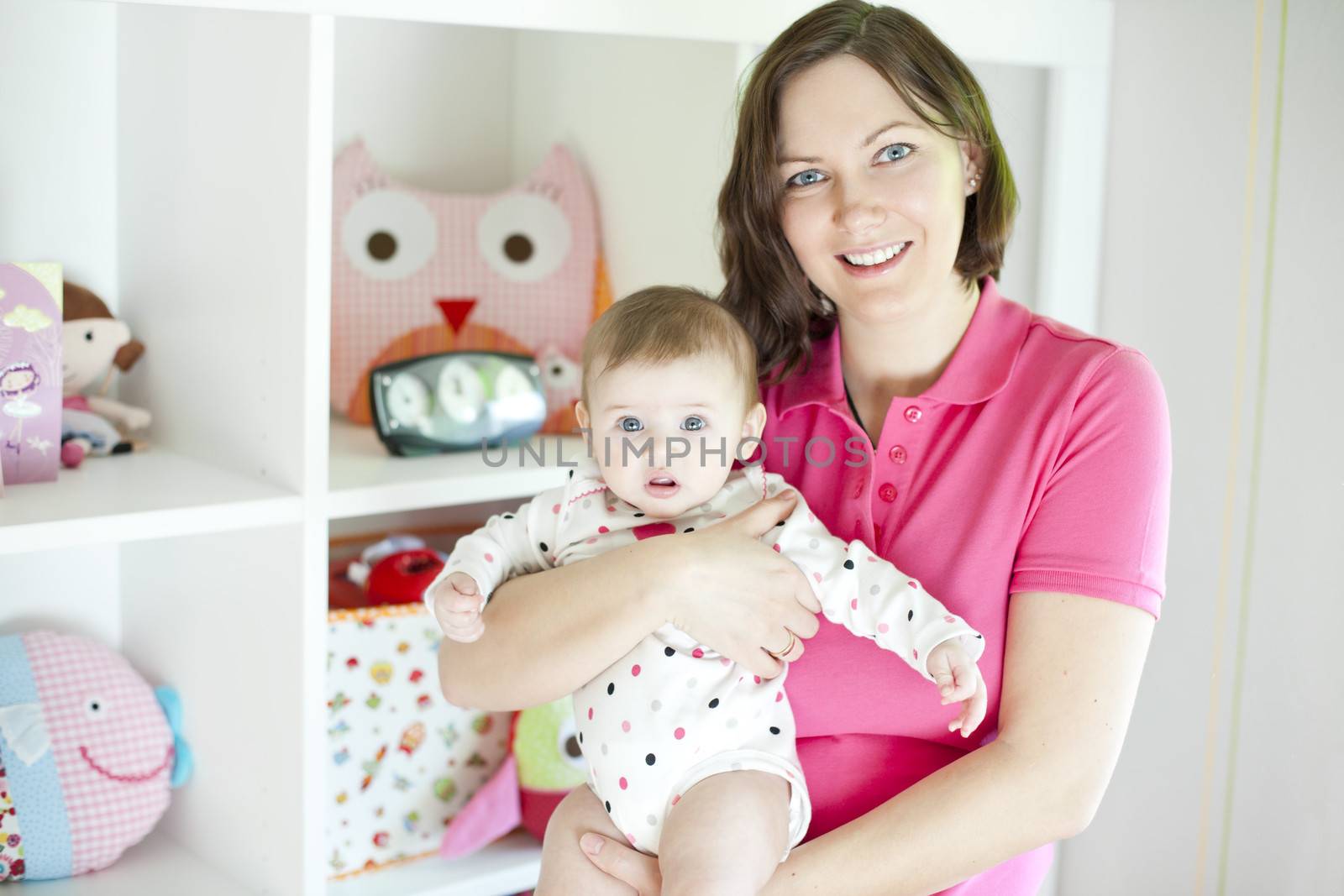Mother with her dauther in a playroom with toys background