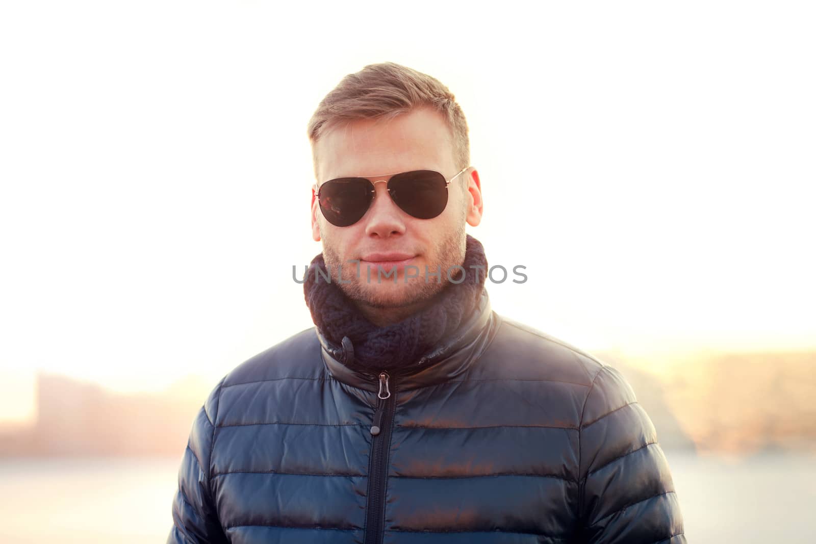 Portrait of young man wearing sunglasses and winter jacket