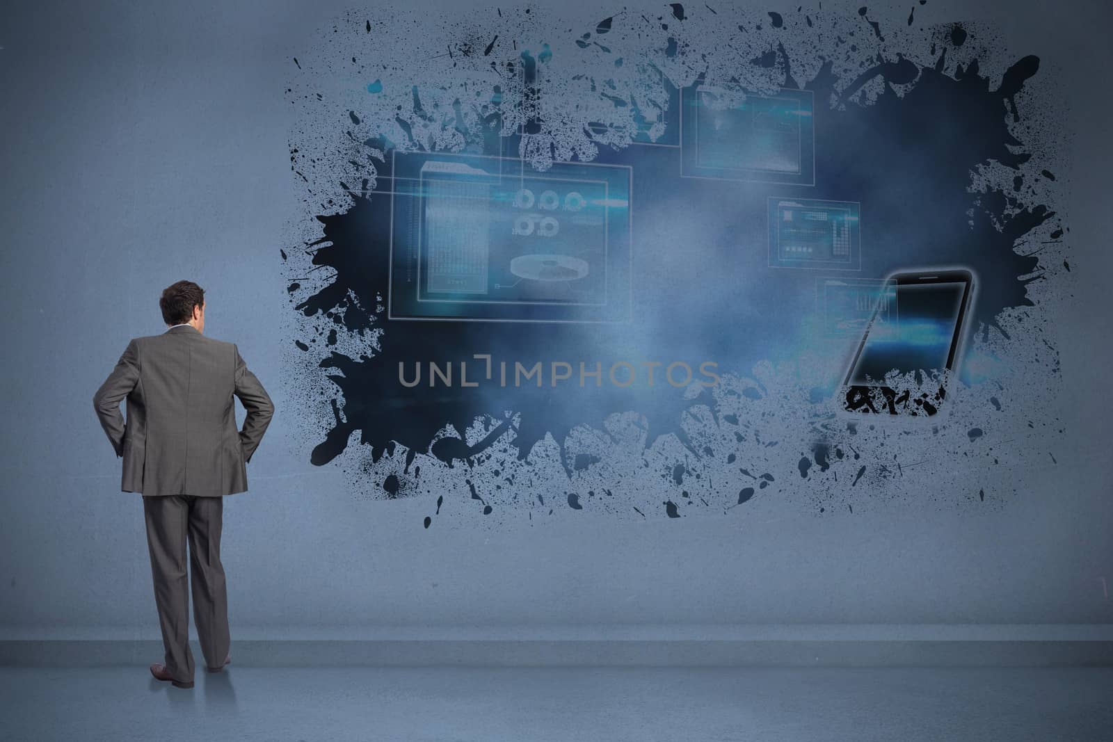 Businessman with hands on hips against splash showing technology interface