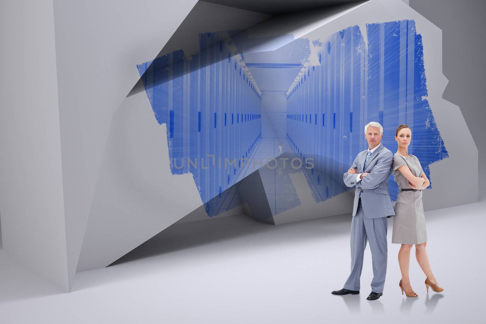 Serious businessman standing back to back with a woman  against abstract screen in room showing server towers