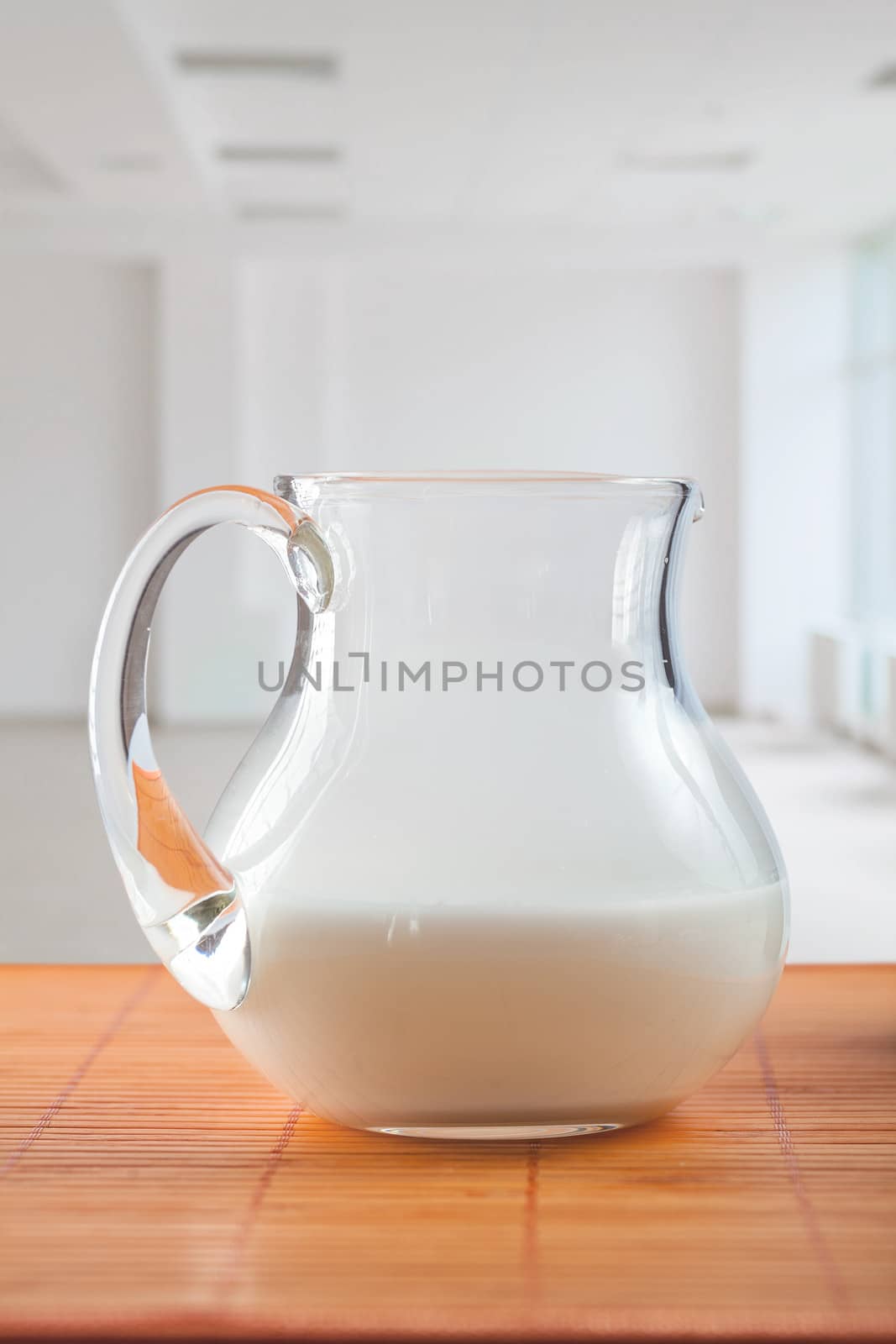 pitcher with milk on table by mihalec