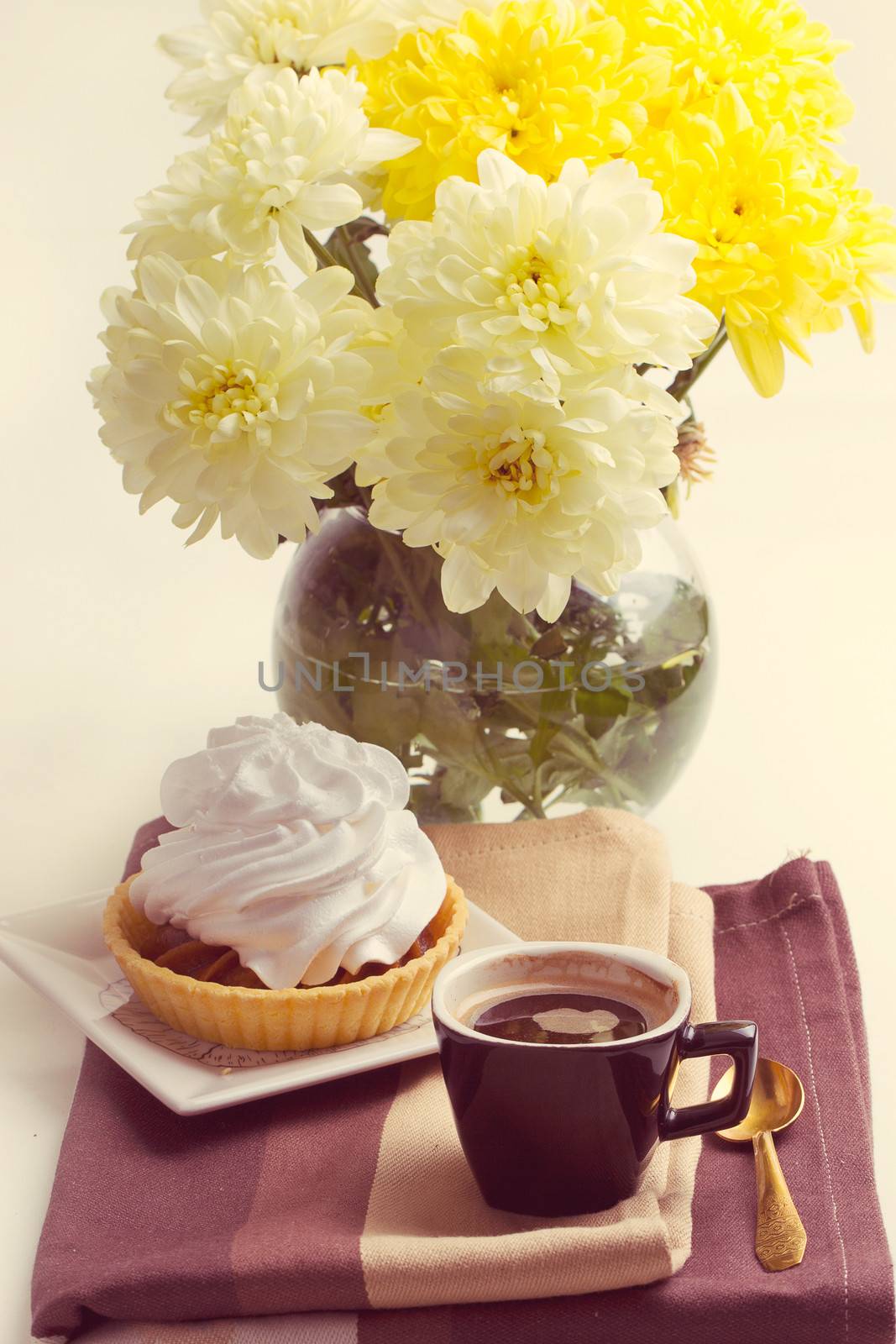 Coffee and cake with whipped cream near chrysanthemums