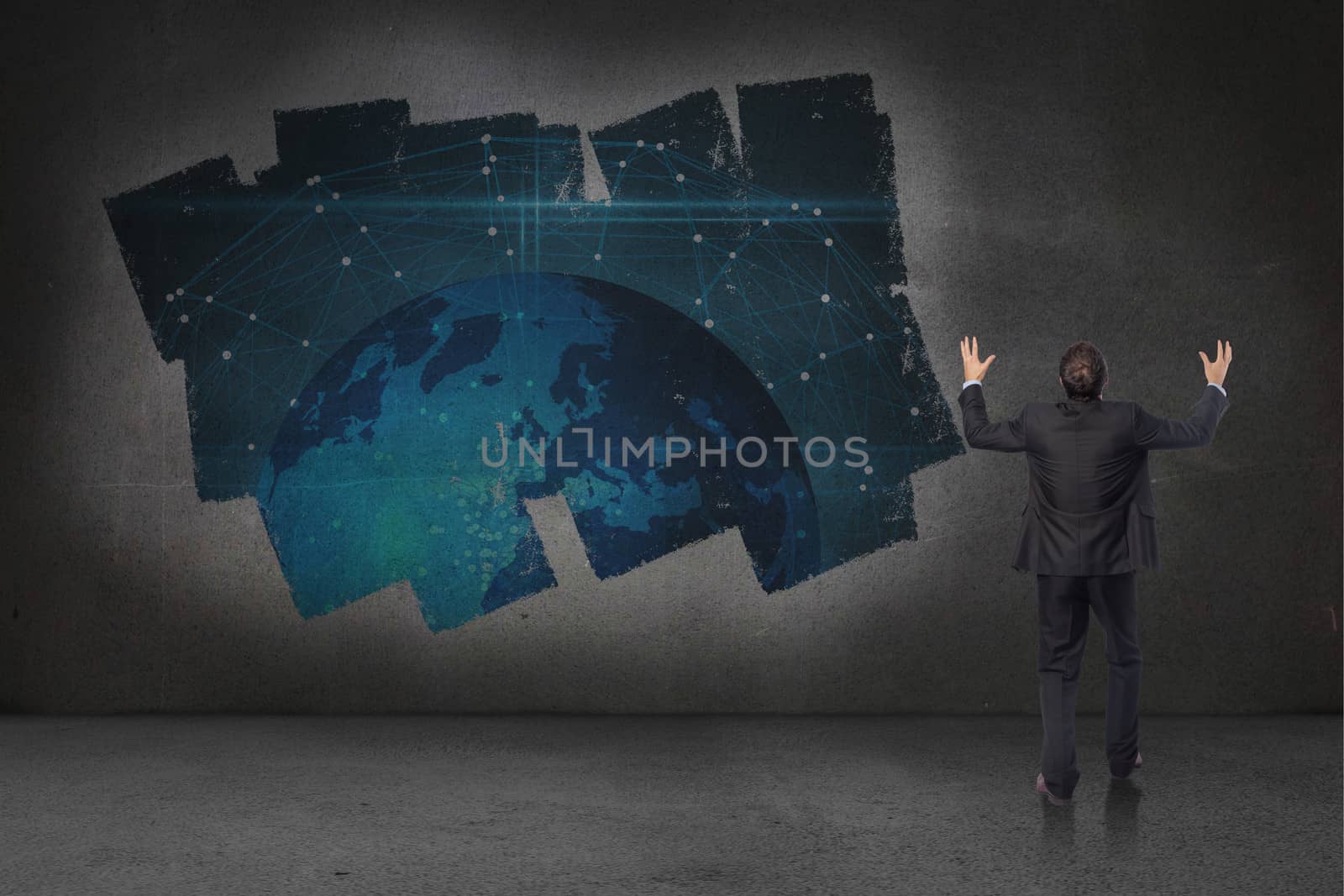 Gesturing businessman against display on wall showing global technology graphic