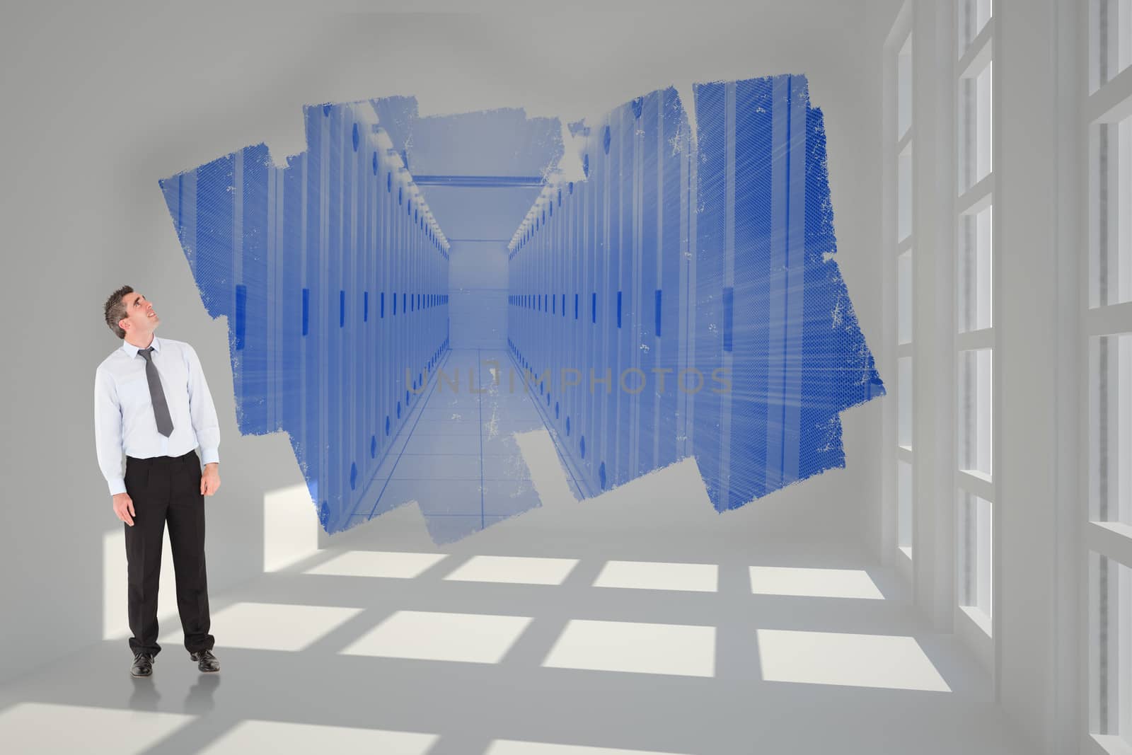 Businessman looking up against abstract screen in room showing server hall