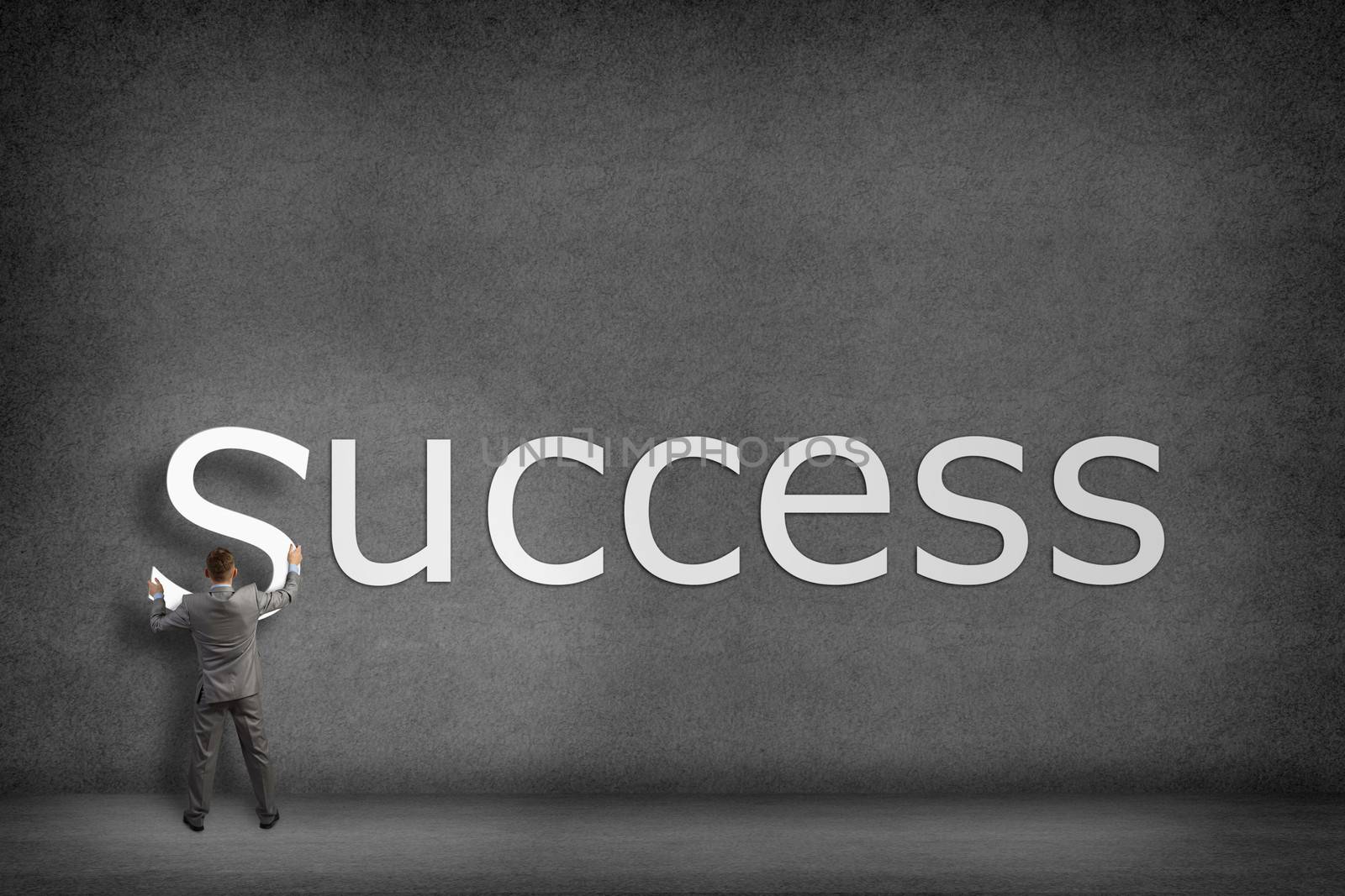 Businessman collects on the wall the word success, places the letter on the wall