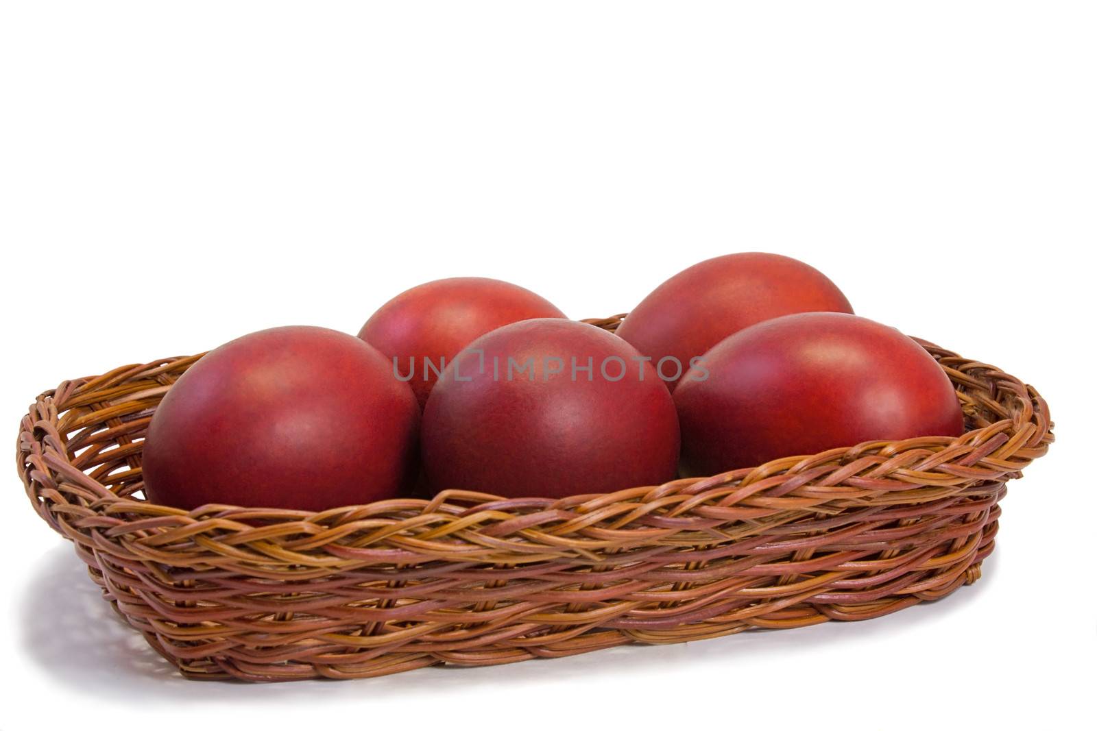 Red Easter eggs in a basket on a white background. by georgina198
