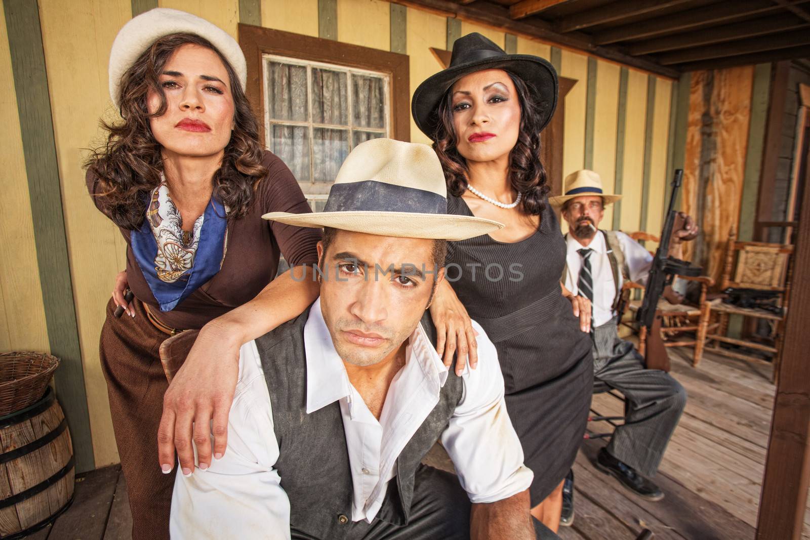 Tough 1920s gangster surrounded by pretty women outside