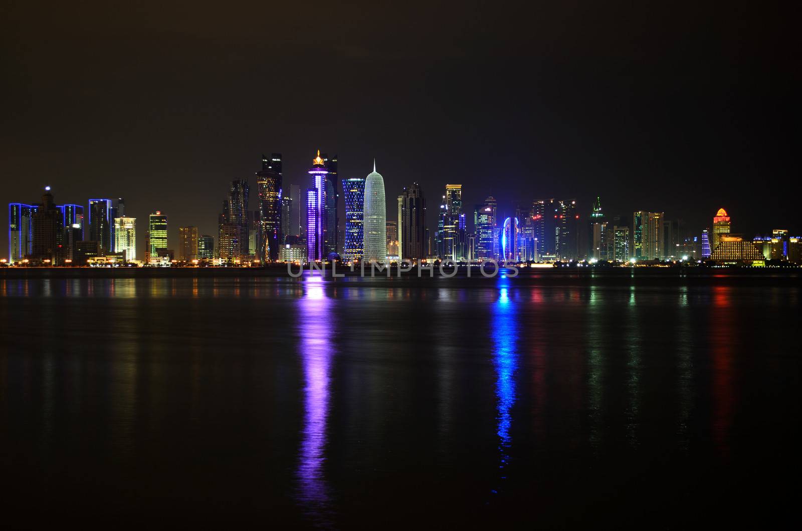 The illuminated skyline of the commercial center of Doha, the capital of the Arabian Gulf country Qatar at night.