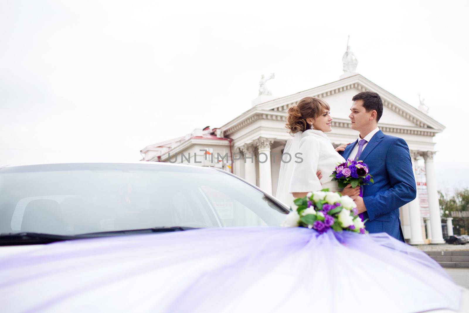 bride and groom near the car