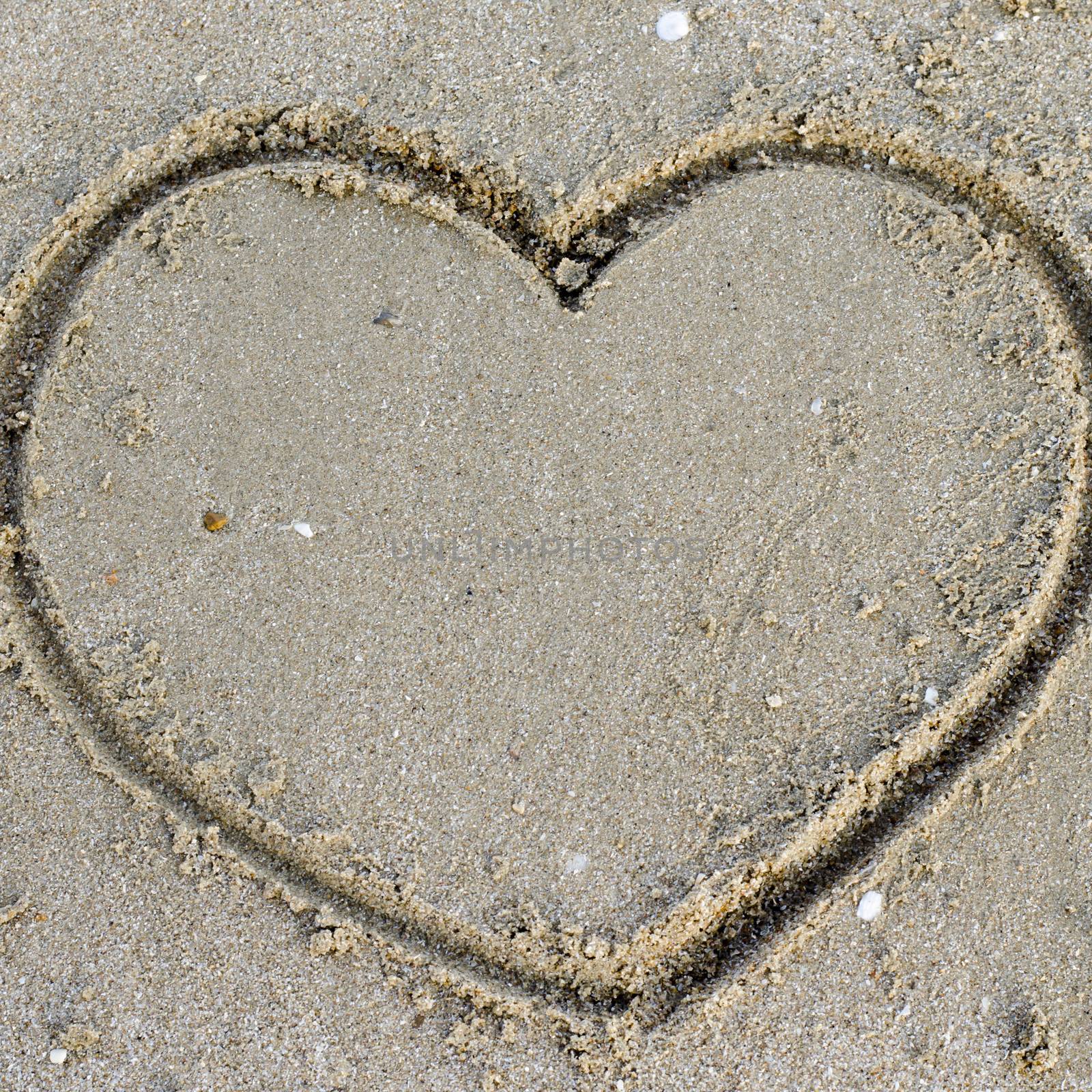 drawing heart on the sand in the beach